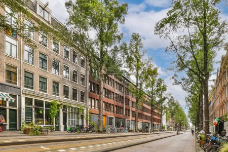 une rue vide à Amsterdam, avec des vélos garés sur le côté et les gens marchant au milieu - ageden