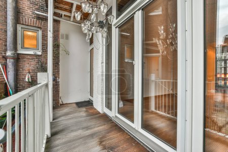 Photo for An outside area with wood flooring and glass doors leading to the patio, which has been used for several years - Royalty Free Image