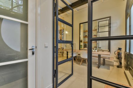 Téléchargez les photos : L'intérieur d'une maison avec une porte vitrée ouverte qui mène à une cuisine et une salle à manger dans la pièce - en image libre de droit