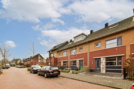 Photo for A street with cars parked on the side and houses in the back ground, all bricked up for sale - Royalty Free Image