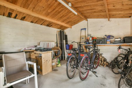 Photo for Amsterdam, Netherlands - 10 April, 2021: a garage with two bikes parked in front of each other bikes and storage boxes on the wall is made out of wood - Royalty Free Image