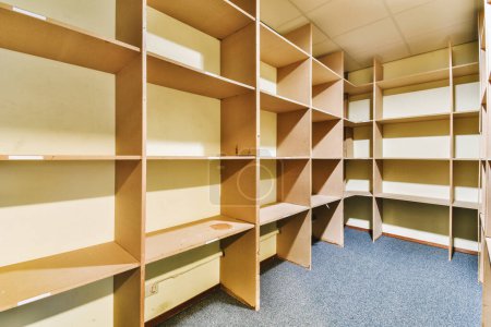 Photo for The inside of a room with many shelves on each side and one shelf at the other end that is empty - Royalty Free Image
