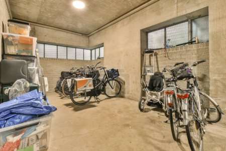 Photo for Amsterdam, Netherlands - 10 April, 2021: two bikes parked in a room next to each other bikes and trash bins on either side of the wall - Royalty Free Image