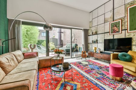Foto de Una sala de estar con alfombras de colores en el suelo y sofás frente a las paredes empapeladas - Imagen libre de derechos