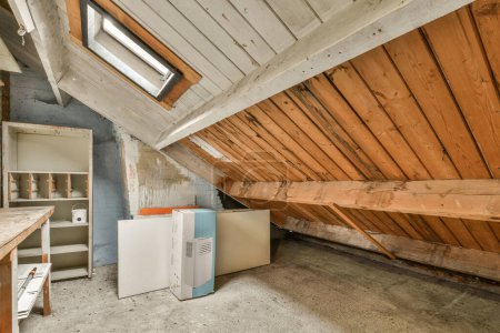 Photo for An unfinished attic with wood paneling on the walls and ceiling that has been stripped off to make room for new appliances - Royalty Free Image