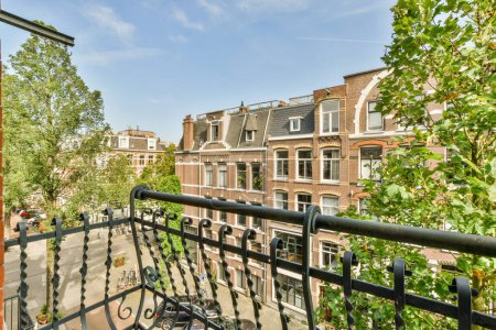 Téléchargez les photos : Amsterdam, Pays-Bas - 10 Avril, 2021 : un balcon avec des vélos garés sur les balustrades et des bâtiments en arrière-plan, vu d'une fenêtre de l'appartement - en image libre de droit