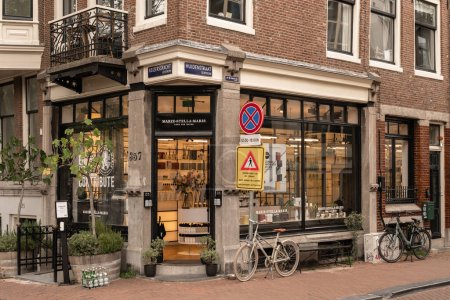 Photo for Amsterdam, Netherlands - 10 April, 2021: a bike parked in front of a store on the side of a street with no parking signs and buildings behind it - Royalty Free Image