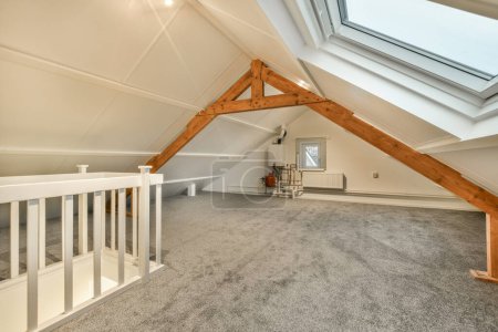 Photo for An attic loft with skylights and carpeted flooring in the attic, which has been used as a home office - Royalty Free Image
