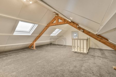 Photo for An attic loft with carpet and skylights on the roof, taken from above looking down to the room below - Royalty Free Image