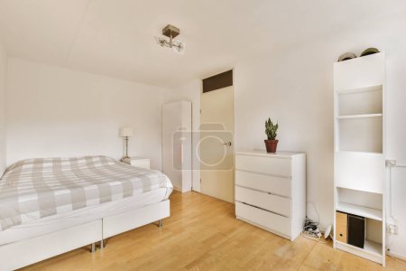a bedroom with a bed, dressers and cupboards on the floor in front of the bed is white
