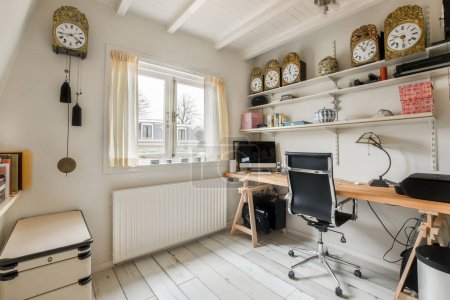 a home office with clocks on the wall and desk in front of window looking out onto an outside view