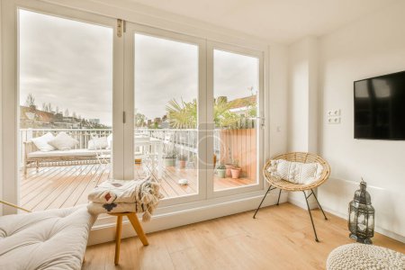 una sala de estar con suelos de madera y puertas correderas de vidrio que se abren al balcón con vistas a la zona de la cubierta del patio trasero