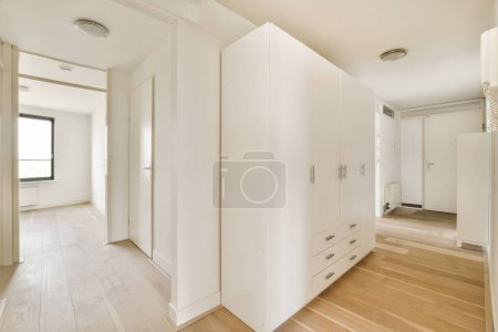Photo for An empty room with wooden floors and white walls, there is a large mirror on the wall to the right - Royalty Free Image