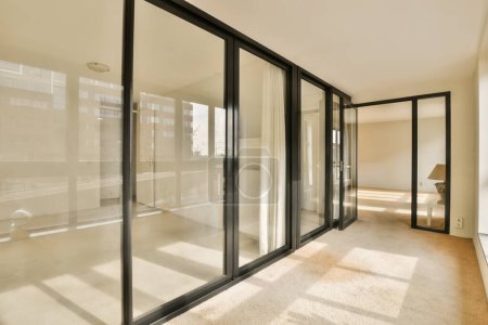 una habitación vacía con puertas correderas de vidrio y ventanas de piso a techo en un nuevo edificio de apartamentos, Londres, Reino Unido foto de stock