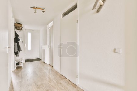 Photo for A long hallway with white walls and wood flooring the room is clean and ready for guests to walk in - Royalty Free Image