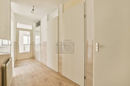 Photo for An empty room with wooden floors and white doors on either side, there is no one person in the photo - Royalty Free Image