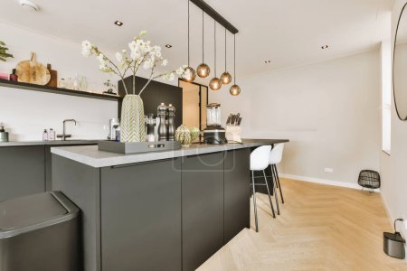 eine moderne Küche mit schwarzen Schränken und weißen Arbeitsplatten in der Mitte des Raumes ist ein großer Spiegel an der Wand