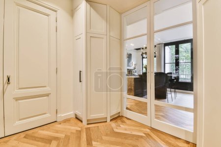 Photo for A room with wooden floors and white closets in the middle part of the room there is a large mirror on the wall - Royalty Free Image
