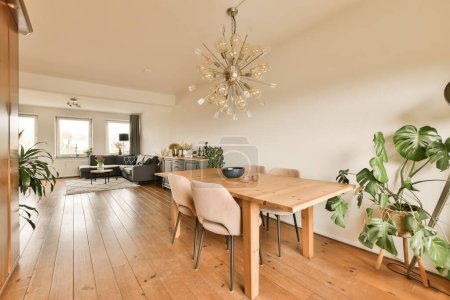 Foto de Un comedor con suelo de madera y un chandel en el centro de la habitación es una sala de estar abierta - Imagen libre de derechos
