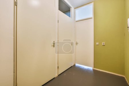 Photo for The inside of a room with two white doors and one door open to reveal another room that is not in use - Royalty Free Image