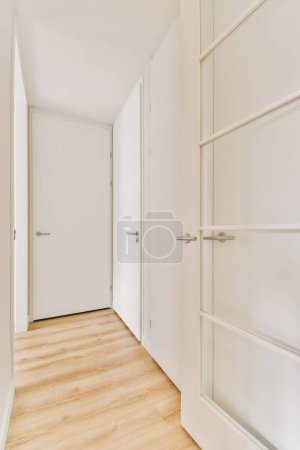 Photo for An empty room with white walls and wood flooring the door is open on the right, there are two closets - Royalty Free Image