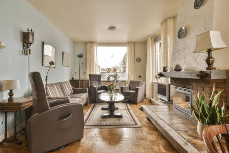 Photo for A living room with couches, chairs and a fire place in the middle part of the room is empty - Royalty Free Image