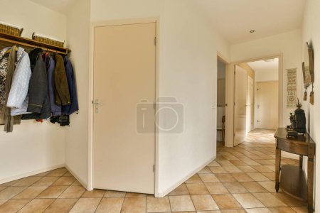 Photo for The inside of a room with clothes hanging on hooks and closets in it, as well to be used - Royalty Free Image