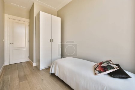Foto de A bedroom with white walls and wood flooring the room has a bed, two wardrobes on either side - Imagen libre de derechos
