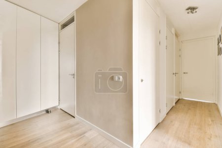 Photo for An empty room with wood floors and white walls, two doors open to reveal another room in the same space - Royalty Free Image