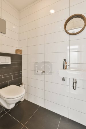 Photo for A modern bathroom with black and white tiles on the walls, toilet and sink in the room is very clean - Royalty Free Image