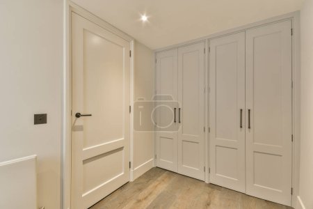 Photo for An empty room with white closets and wood floors in the room is very clean, but there is no one - Royalty Free Image