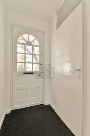 Téléchargez les photos : Une pièce vide avec une porte blanche et un tapis noir sur le sol devant la porte est une fenêtre - en image libre de droit