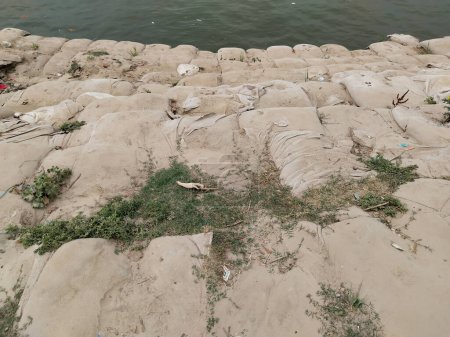 Téléchargez les photos : Rivière Ganga avec des sacs de sable. Sacs de sable pour les catastrophes liées aux sédiments. Mettre le sable dans un sac à conteneurs souple. Mettre le sable dans un sac en vrac - en image libre de droit