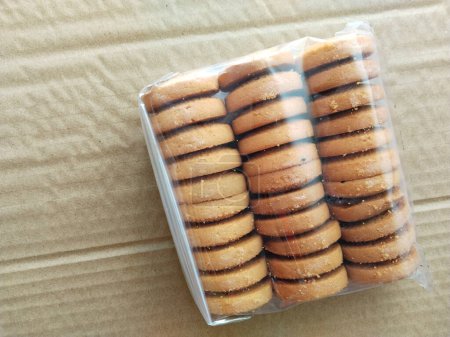 Téléchargez les photos : Emballage de biscuits sur un fond brun. Biscuits en emballage plastique. copier l'espace, placer votre texte - en image libre de droit