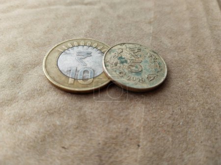 Foto de Moneda india cinco, monedas de diez rupias aisladas en el fondo wheatish. - Imagen libre de derechos