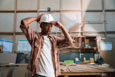 Téléchargez les photos : Jeune charpentier africain dans une usine de charpentier - en image libre de droit