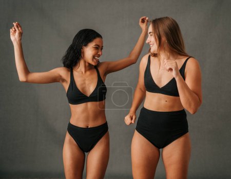 Foto de Dos amigas divirtiéndose bailando en el estudio mostrando brazos bien tonificados. Foto de alta calidad - Imagen libre de derechos