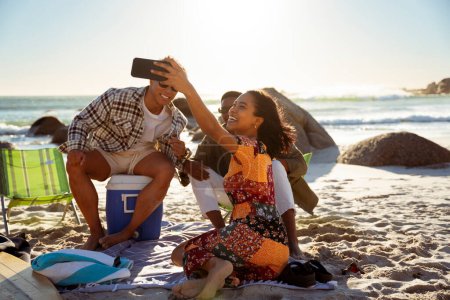Photo for A woman taking a selfie with her friends on the beach. Sunset. High quality photo - Royalty Free Image