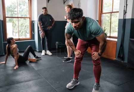 Photo for A group of individuals are engaging in exercises, working on different muscle groups such as arms, legs, and thighs. They are wearing shorts and moving around the gym near the doors and windows - Royalty Free Image