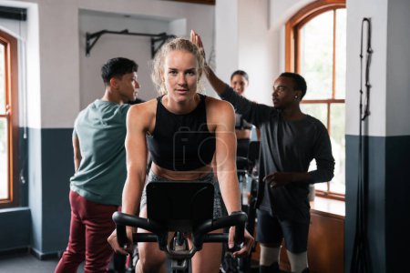 Photo for Individuals are pedaling on stationary bicycles in the gym, wearing cycling shorts to work their leg muscles. The sports equipment includes wheels, tires, and doors for entry - Royalty Free Image