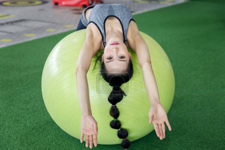 Téléchargez les photos : Femme de remise en forme faisant abdos croque sur une balle de remise en forme à la salle de gym. Concept de mode de vie sain. - en image libre de droit