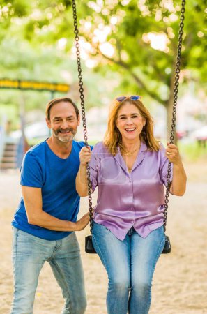 Foto de Macho y mujer pareja madura juntos feliz al aire libre en un parque infantil. amor adulto europeo. - Imagen libre de derechos