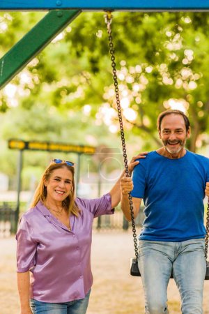 Photo for Male and woman mature couple together happy outdoors in a park playground. european adult love. - Royalty Free Image