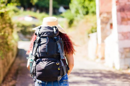 Téléchargez les photos : Latina personnes voyagent avec sac à dos pendant un voyage de loisirs d'été à pied dans la campagne - en image libre de droit