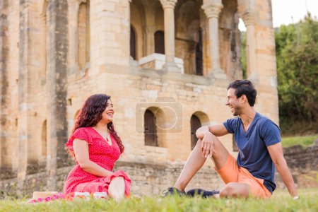 Photo for Mid adult indian man and latinx woman in front of unesco medieval pre-romanesque historic church. european monument. two people together. - Royalty Free Image