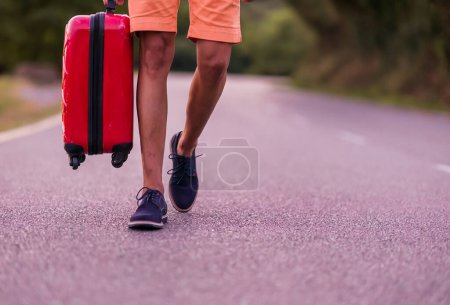 Foto de 40s persona caminando por la carretera con llevar en el equipaje. éxito para viajar aventura con riesgo y adulto solitario en el extranjero. espacio vacío - Imagen libre de derechos