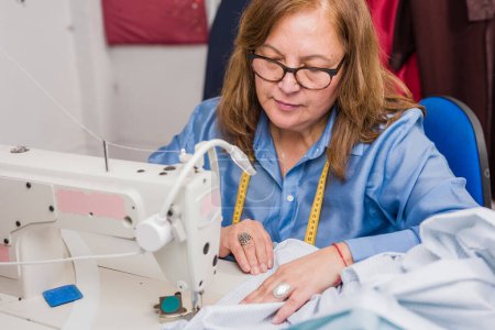 Téléchargez les photos : Portrait mature chilien d'une personne travaillant dans l'industrie textile. Réutiliser le tissu issu de l'économie circulaire des petites entreprises pour une industrie textile écologique et durable. - en image libre de droit