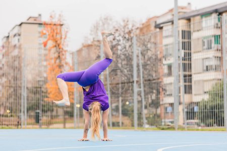 Photo for Acrobat strong, healthy training. Upside down coordination achievement for gymnastics challenge with effort and energy or stamina. Attractive skill on the city. - Royalty Free Image