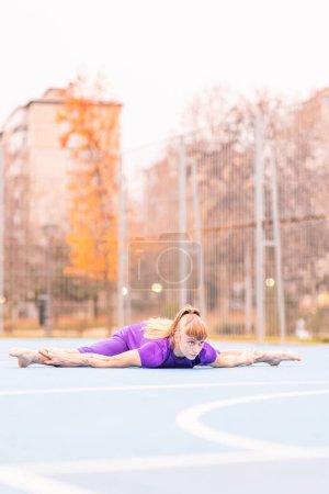 Photo for Body exercise flexible training outdoor on the city. Wellness active adult strength training gymnastics. - Royalty Free Image