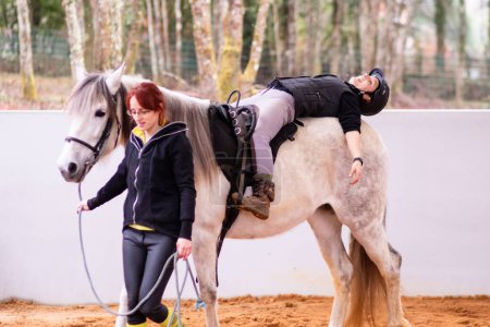 Photo for Professional treatment therapy on horseback equine therapy. medical assistance therapist for phychotherapy rider improving neurologic functions. - Royalty Free Image